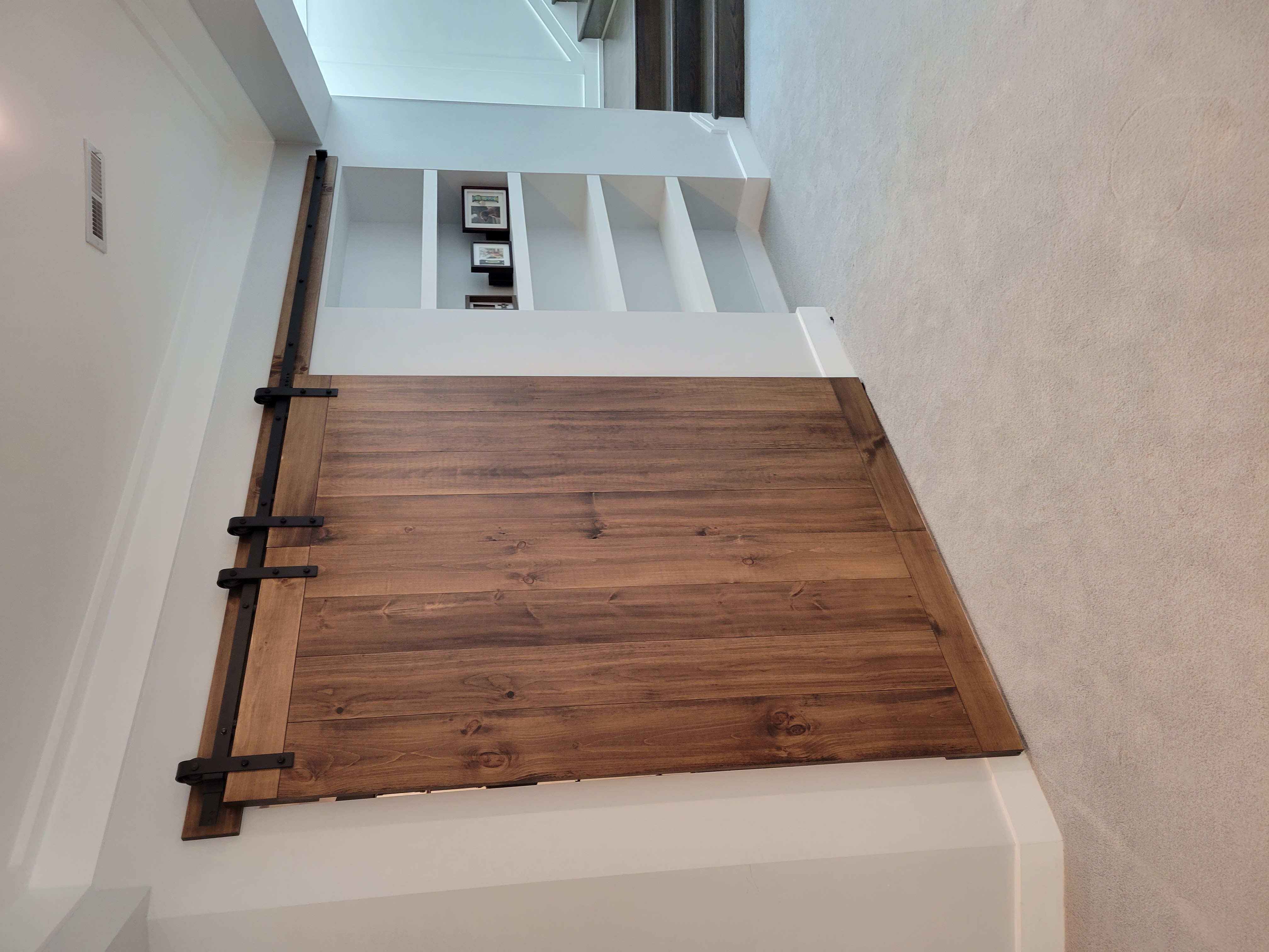 Custom dark walnut barn door on staircase landing