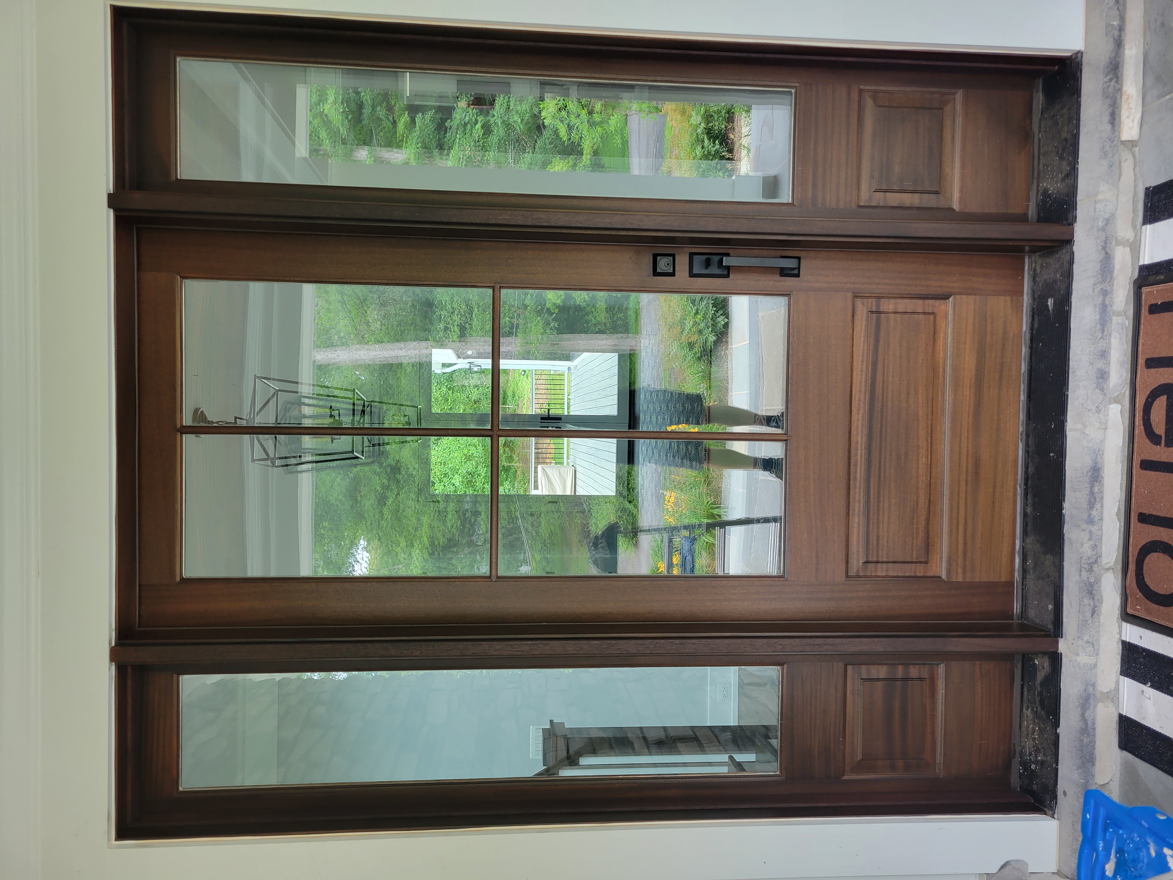 Dark walnut entry door with glass panels and sidelights