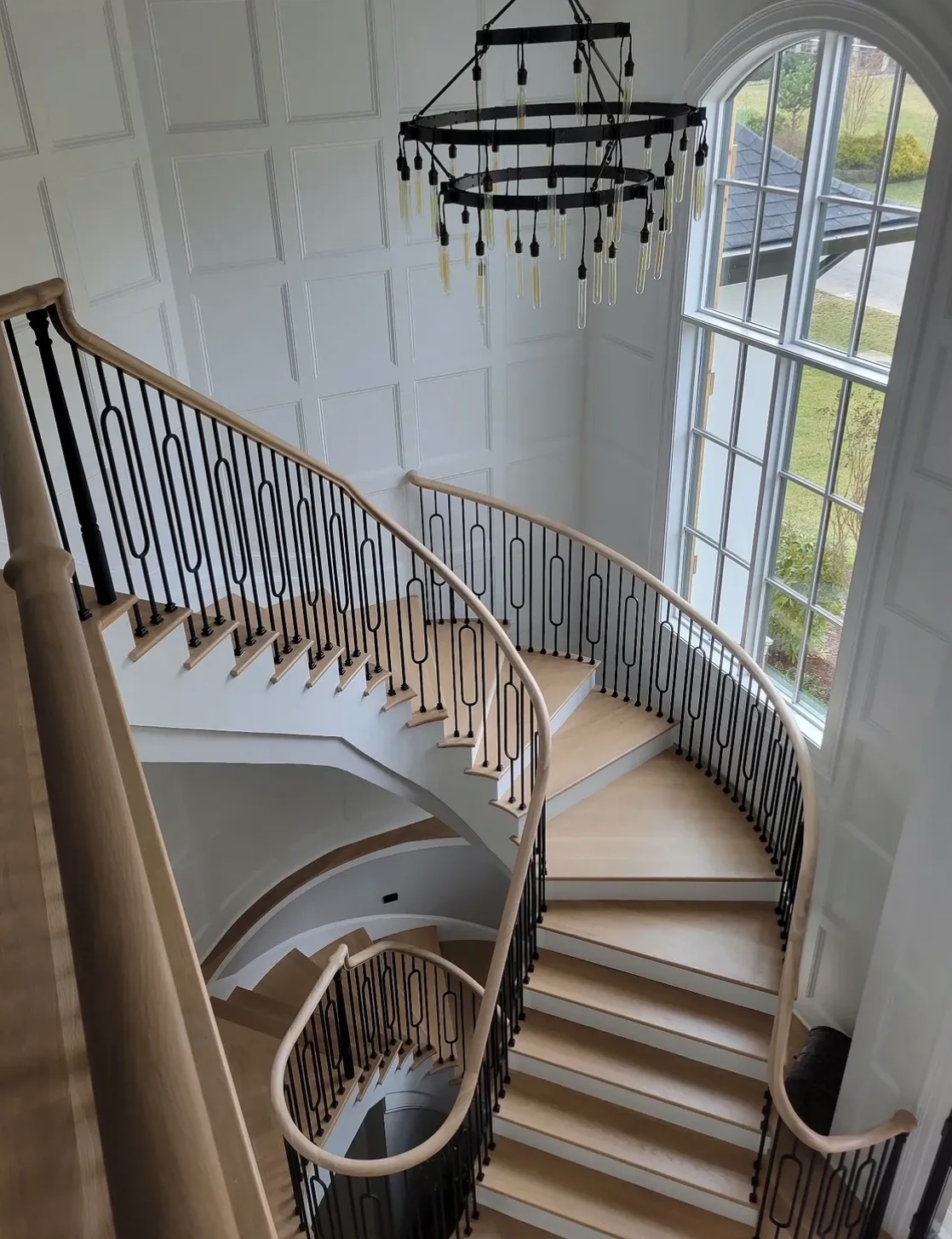 Finished curved staircase with iron balusters